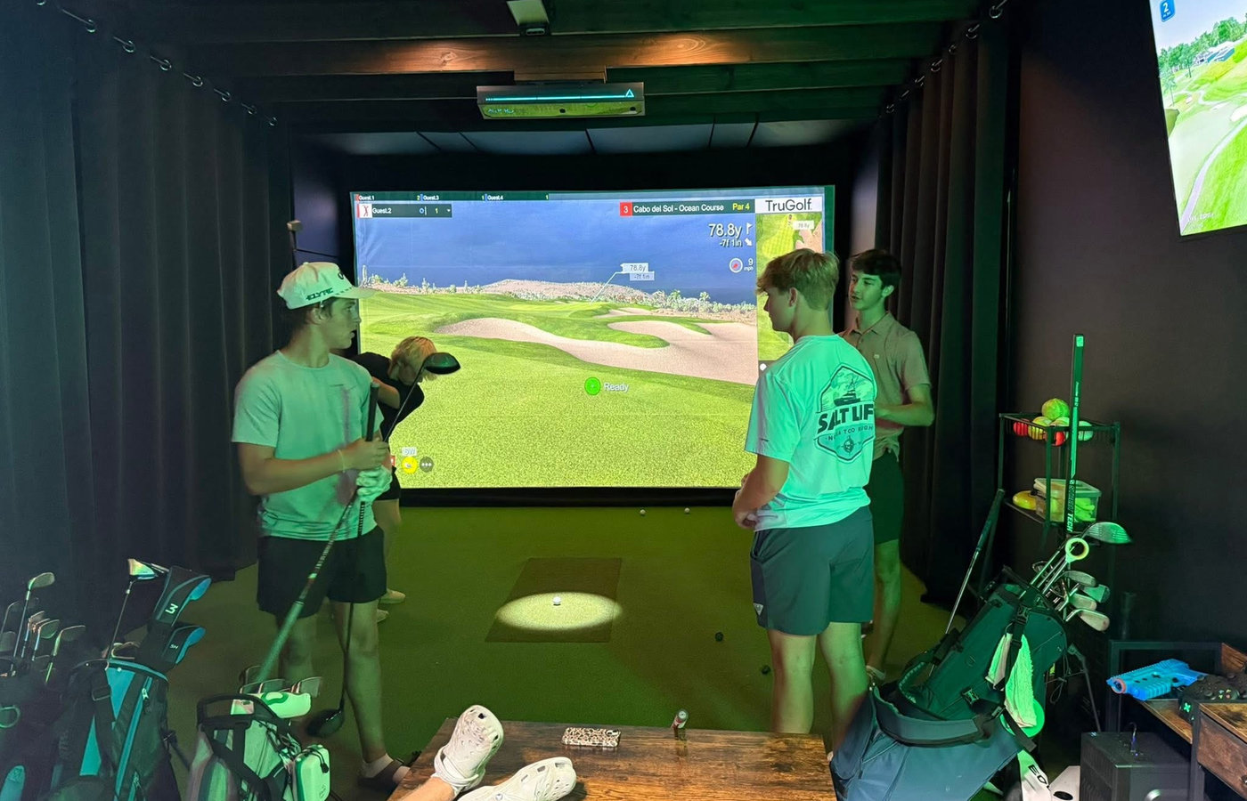 Golfer mid-swing in a Golf318 simulator bay