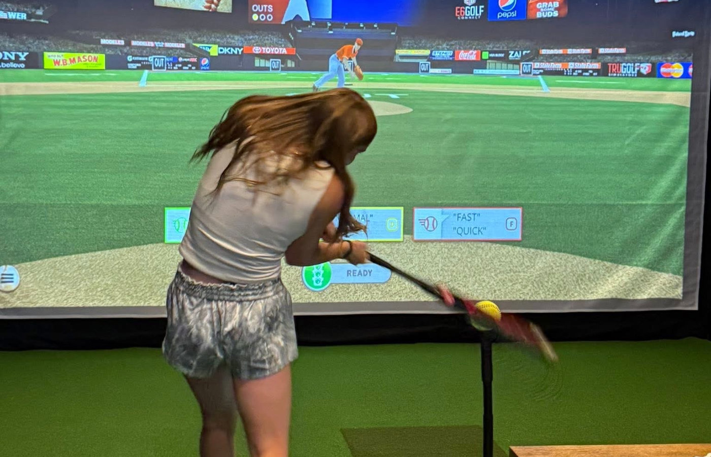 Golf ball on the hitting mat in front of the sim screen